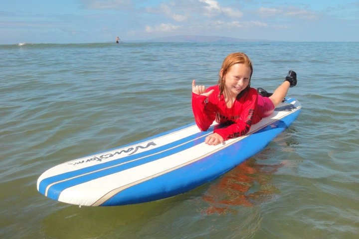 a girl riding a wave on a surf board on a body of water